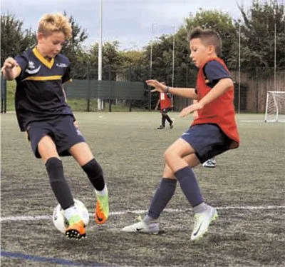 Two players contesting the ball on an artificial pitch